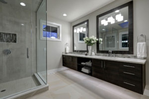 bathroom with large glass walk-in shower large dual vanity with mosaic backsplash.